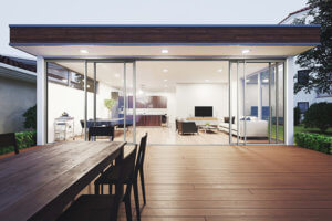 Visuel d'ambiance coulissant six vantaux Visuel d'ambiance d'un coulissant aluminium STYLIUM six vantaux vue d'une terrasse extérieure